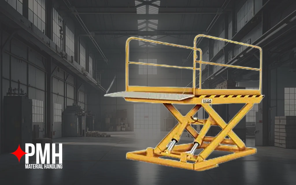 Yellow hydraulic scissor lift table with safety rails and loading ramp positioned inside an industrial warehouse, designed for lifting and transporting materials safely in material handling operations.